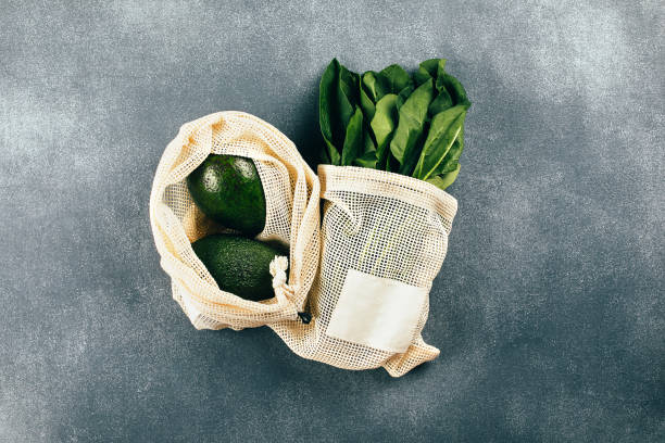 istock Avocado and spinach in eco cotton bags on table. Zero waste shopping concept. Flat lay, top view 1433406561