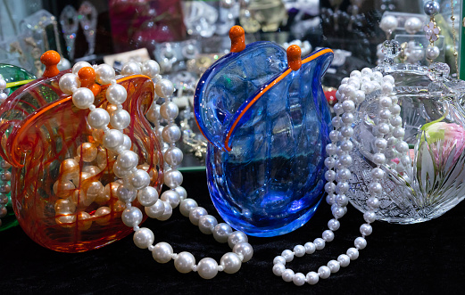 Beads of large pearls in glass vases in the shape of an old purse.