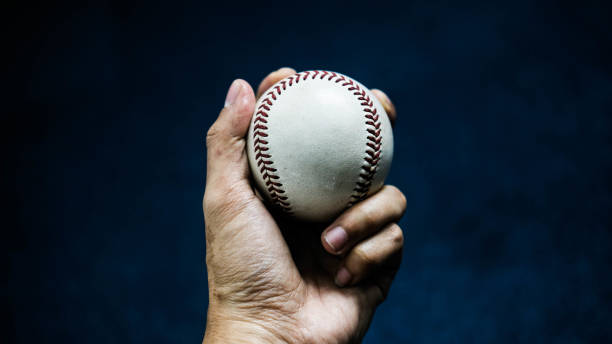 istock Selective focus of man holding baseball ball isolated on black background. 1433411755