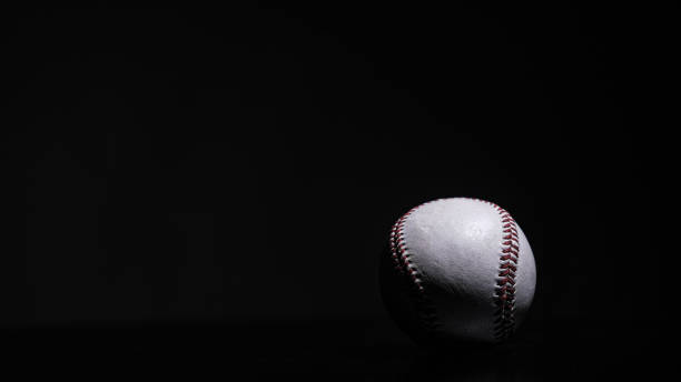 istock White leather baseball poses on black background 1433411791