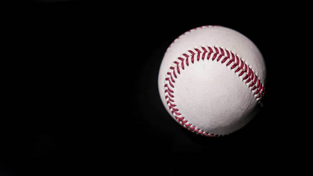 istock White leather baseball poses on black background 1433411865