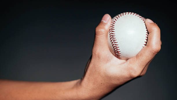 istock Selective focus of man holding baseball ball isolated on black background. 1433411892