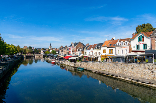 Amiens, France - 12 September, 2022: the canals of the Somme River and the historic old city center of Amiens under a blue sky