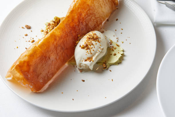 istock baklava with pistachios and ice cream on a white plate 1433416523