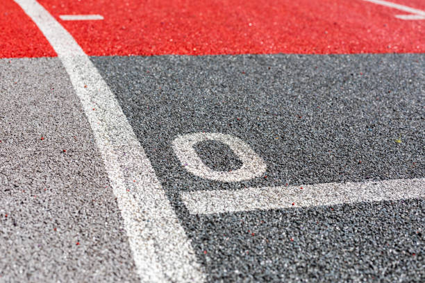 Zero on running track with protective coating of rubber granules. Starting point of concept Zero on a running track with a protective coating of rubber granules. The starting point of the concept red cushion covers stock pictures, royalty-free photos & images