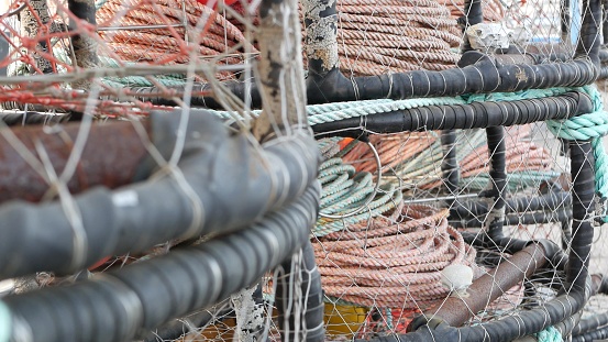 Traps, ropes and cages on pier, commercial dock, fishing industry, Monterey California USA. Empty pots, creels for fish seafood catching in port. Many fisherman's nets and baskets in seaport. Fishery.