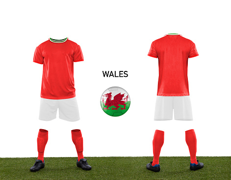 Uniform and ball with the flag of the WALES national team participating in Qatar 2022 with a grass floor on a white background.