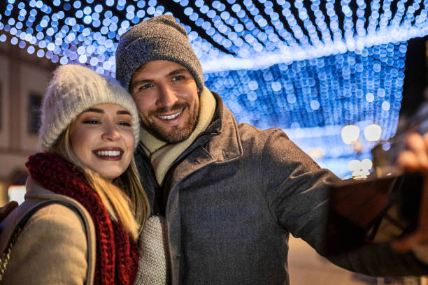 istock Young couple having fun outdoors on Christmas making selfie 1433424386