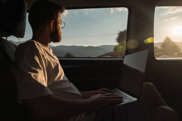 istock man working from her laptop while traveling in daylight in a private vehicle 1433425814