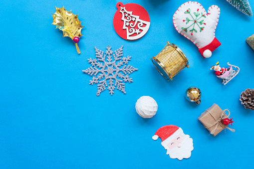Christmas related objects and Christmas ornaments, gifts on blue background