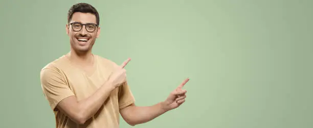 Photo of Banner of smiling guy in beige t-shirt and eyewear, showing commercial offer on right with hands