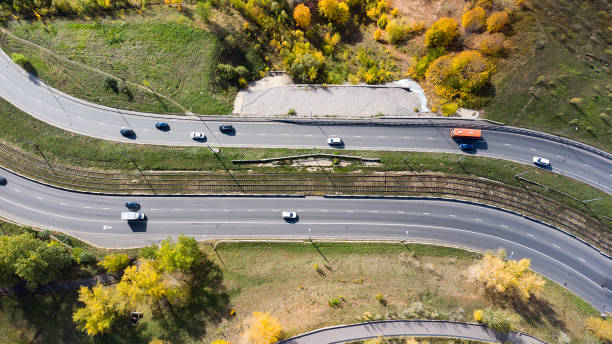 vista aérea de la carretera con un bosque de otoño y una ranura en la carretera. - road winding road mountain spiral staircase fotografías e imágenes de stock