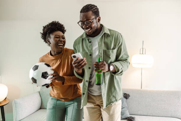 African-American couple celebrating  good result of their sport team stock photo