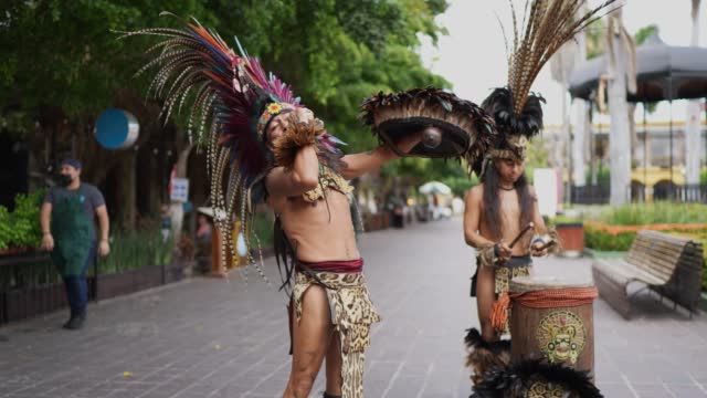 Aztec performers playing instruments outdoors