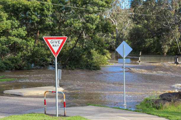 istock give way sign and river flooding over road 1433441993