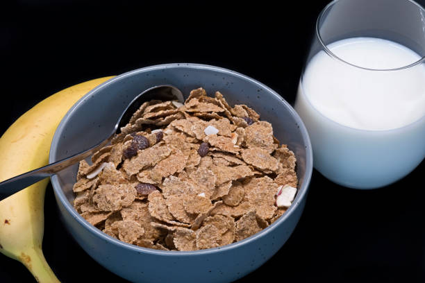 eine schüssel kleieflocken mit getrockneten früchten einschließlich banane und rosinen eine gute mischung aus obst und ballaststoffen. - bran cereal stock-fotos und bilder