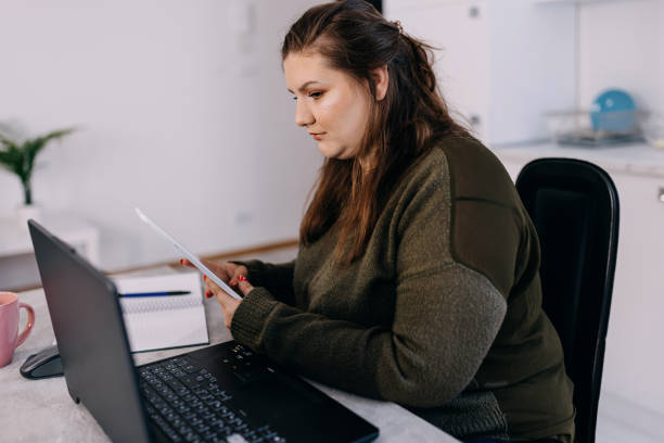 istock Businesswoman using laptop and digital tablet for work at home 1433445130