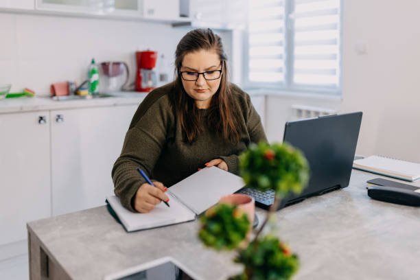 A young student with eyeglasses following an online lesson