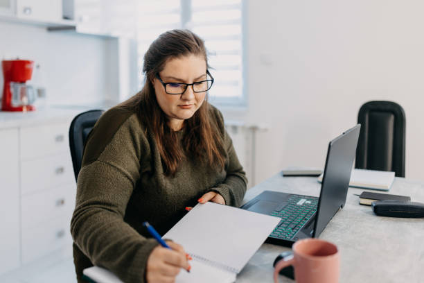 istock Woman with glasses hand writing in note pad 1433445203