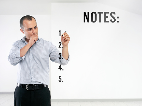 Man taking notes on a transparent wipe board