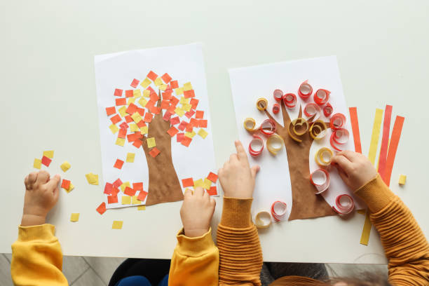 los niños hacen una aplicación, vista superior, manos de cerca. clase magistral de otoño - craft project fotografías e imágenes de stock