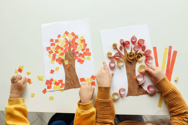 Children make an application, top view, close-up hands. Autumn master class stock photo