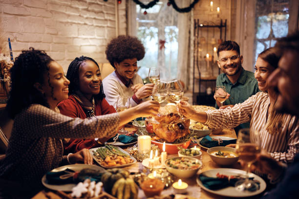 istock Happy friends toasting with wine during Thanksgiving dinner at dining table. 1433453852