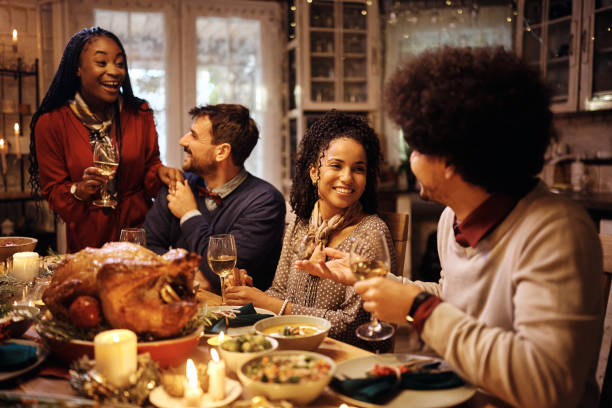 istock Young happy people talking and drinking wine during Thanksgiving dinner at home. 1433453877