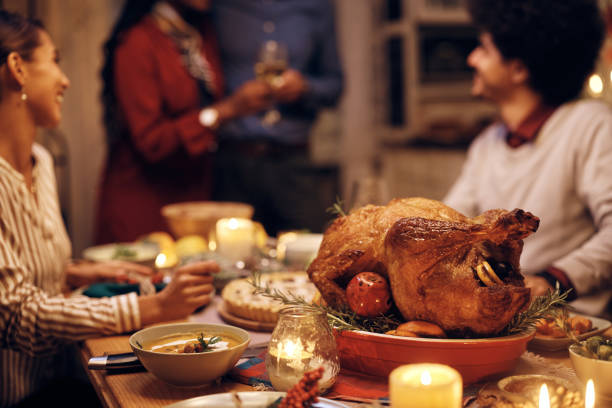istock Close up of Thanksgiving turkey at dining table during dinner party. 1433453948