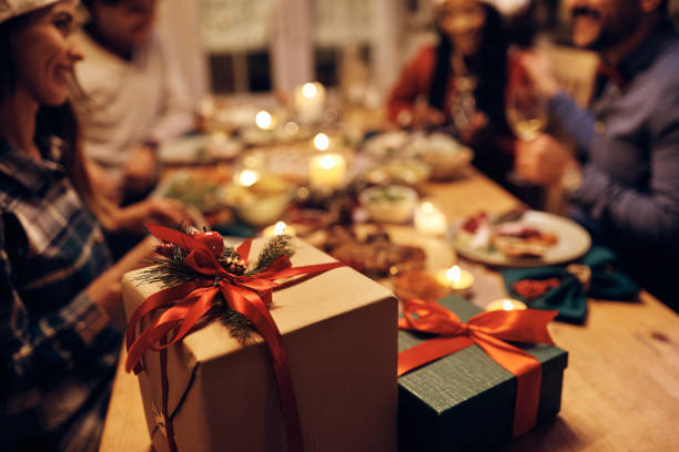 istock Christmas presents at dining table with people in the background. 1433454051