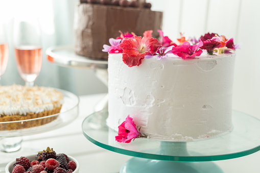 decoration with cakes, pie, glasses with champagne and fruit, table served for celebration, pastry shop with fresh food, details and background