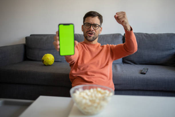Man watching soccer match on TV Excited man cheering while watching tv at home online soccer free betting stock pictures, royalty-free photos & images