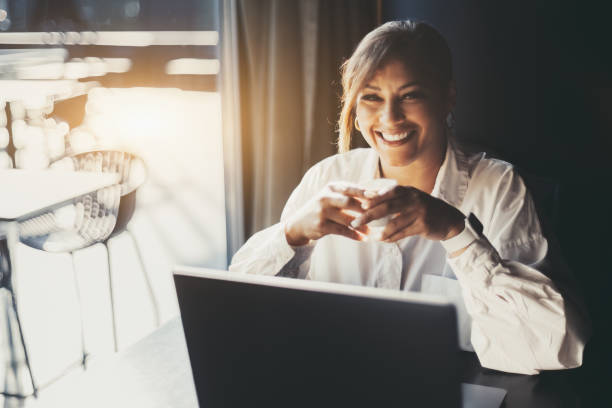 istock Smiling woman with laptop and coffee 1433468974