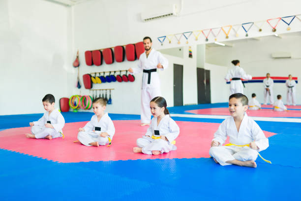 Little children training karate or taekwondo during a martial art class with a coach