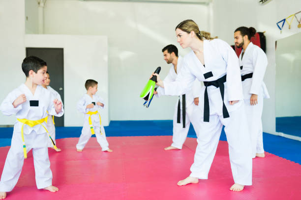 istock Kids training with coaches at martial arts school 1433470071