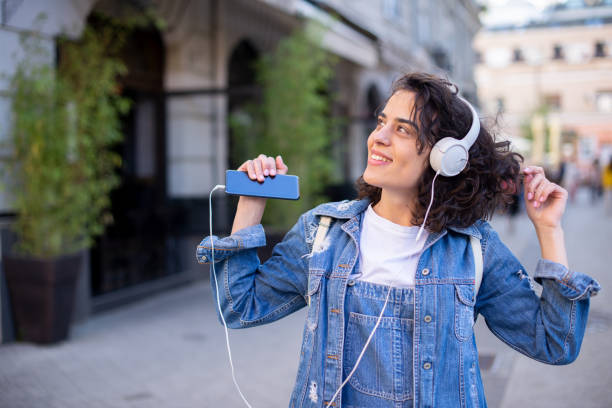 portret podekscytowanej dziewczyny cieszącej się muzyką w mieście - youth culture audio zdjęcia i obrazy z banku zdjęć