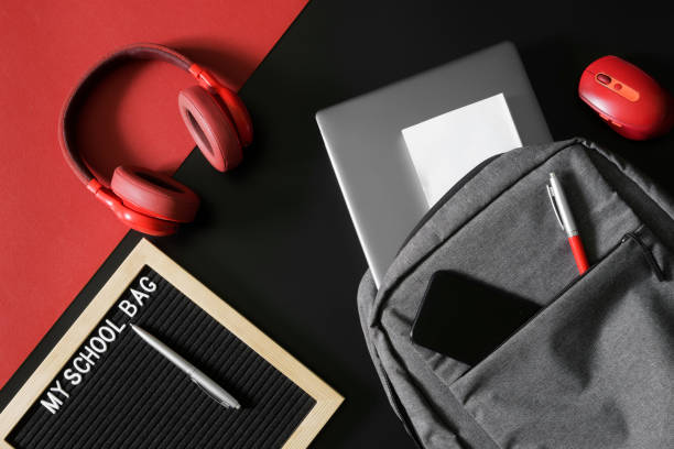 istock Gray urban backpack with a laptop, mobile, pen, headphones, mouse and notepad or textbook next to the inscription my shool bag. Concept of gadgets of a modern schoolboy or student. 1433473589