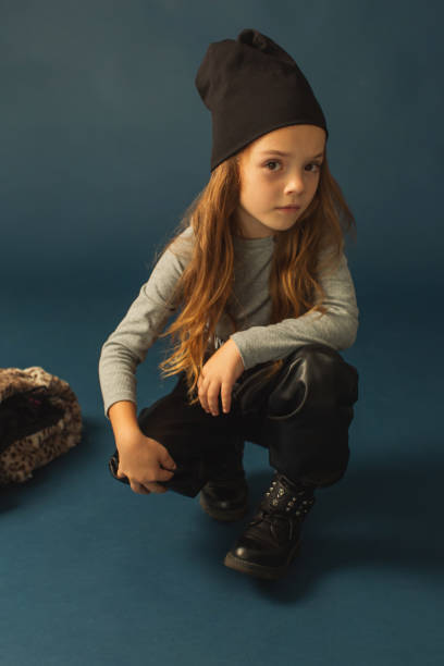 garota ruiva em roupas quentes de outono em estúdio em fundo azul escuro. menina com cabelo comprido em camiseta e chapéu. retrato - little girls autumn child red hair - fotografias e filmes do acervo