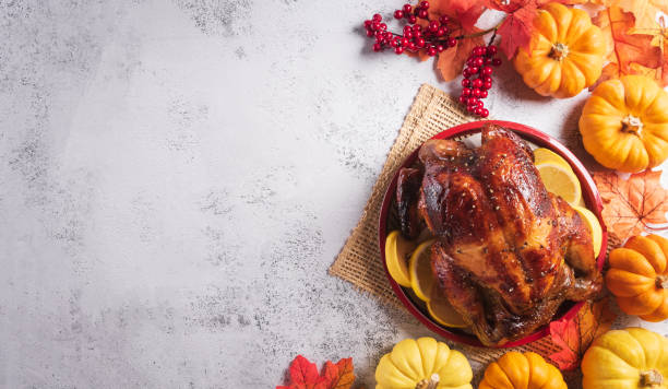 istock Thanksgiving dinner background concept with turkey roasted and all sides dishes, fall leaves, pumpkin and seasonal autumnal decor on dark stone background, top view, copy space. 1433484498