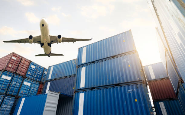 Air logistics. Cargo airplane flying above stack of logistic container. Cargo and shipping business. Container ship for export logistic. Logistic industry from port to port. Freight transportation. stock photo