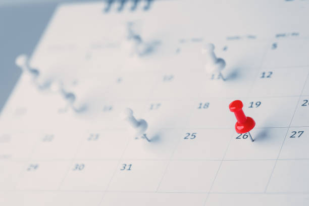 Embroidered red pins on a calendar event Planner calendar,clock to set timetable organize schedule,planning for business meeting or travel planning concept.