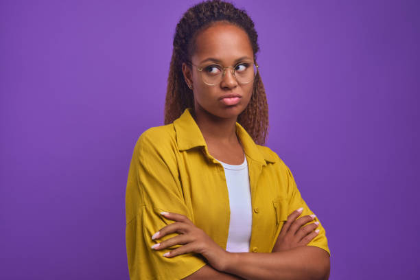 une jeune femme afro-américaine offensée fait la moue les lèvres et croise les bras - disgust women african ethnicity human face photos et images de collection