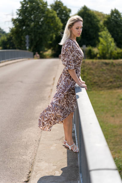 istock Middle aged blond woman standing on a bridge 1433514043
