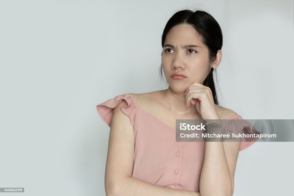 Asian beautiful woman rise chin on hand with thoughtful and confusing and question in mind Asian beautiful woman rise chin on hand with thoughtful and confusing and a question in mind Asian and Indian Ethnicities Stock Photo