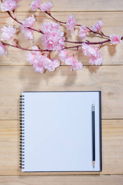 istock open note book with pink sakura flowers on wooden background 1433522343