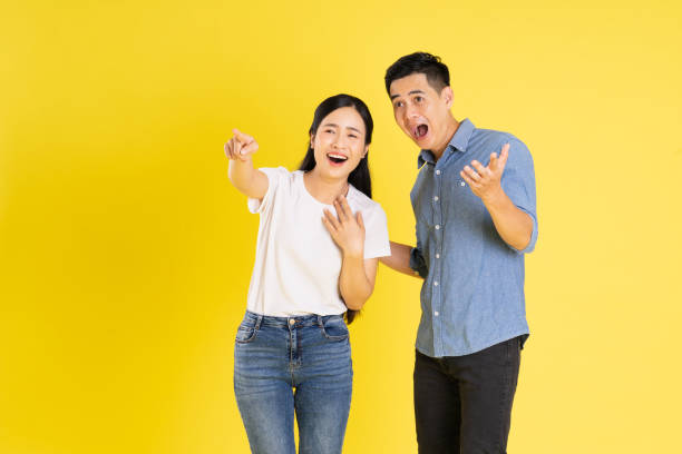 istock image of asian couple posing on yellow background 1433523204