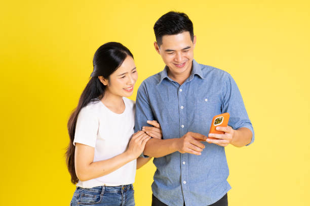 istock image of asian couple posing on yellow background 1433523626