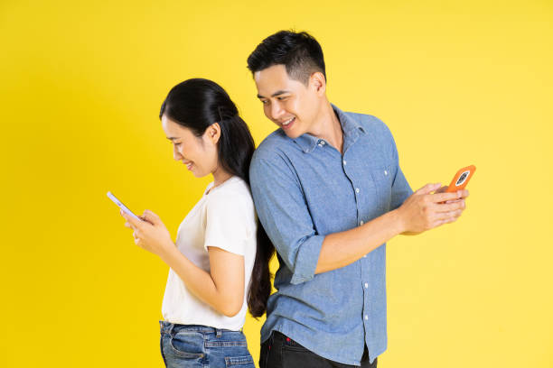 istock image of asian couple posing on yellow background 1433523675