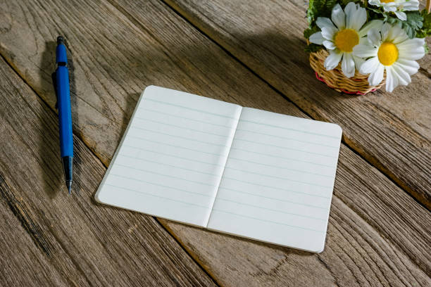 istock open note book with clutch-type pencil on wood background 1433523983