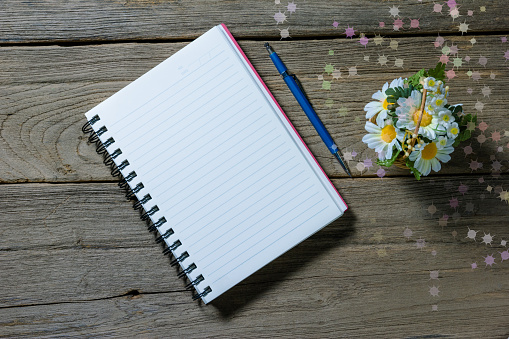 open note book with clutch-type pencil on wood background